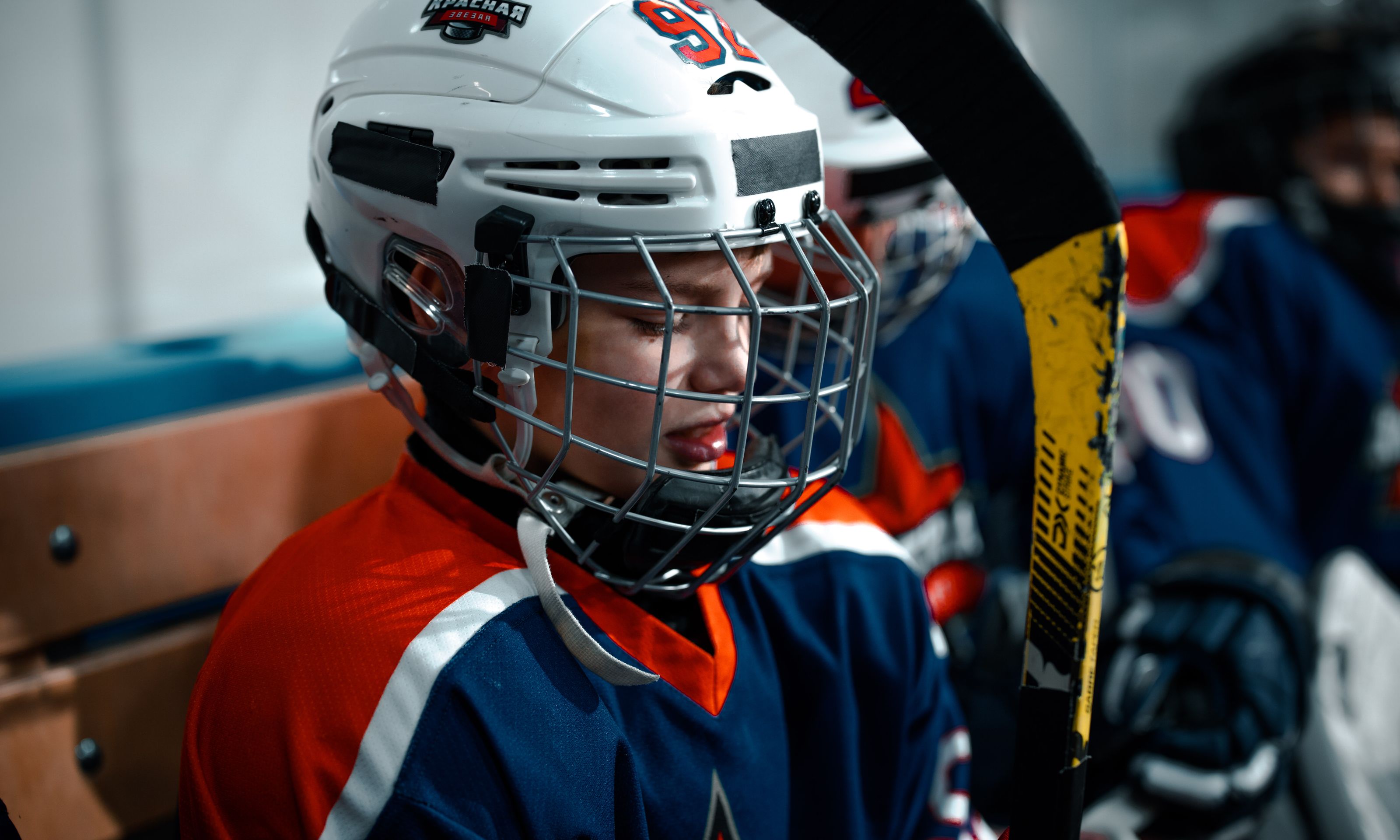 Close-up of a young ice hockey player in full gear, focused and ready for the game.